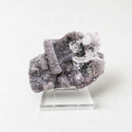 a clear glass display case containing a large, irregularly shaped crystal with a mix of white and gray hues.