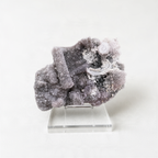 a clear glass display case containing a large, irregularly shaped crystal with a mix of white and gray hues.