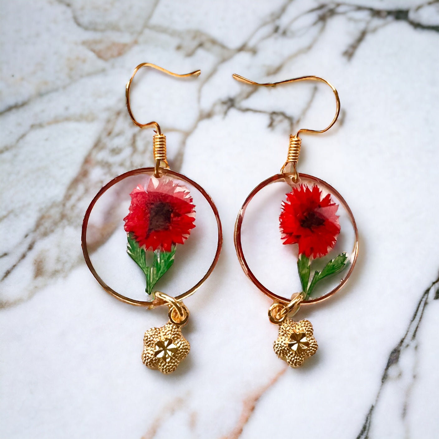 Rote und goldene Ohrringe mit getrockneten Blumen