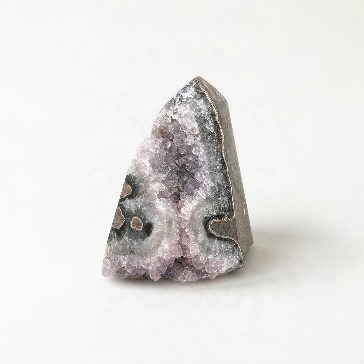 A single, unique crystal formation with a jagged, triangular shape and a mix of purple and gray hues.