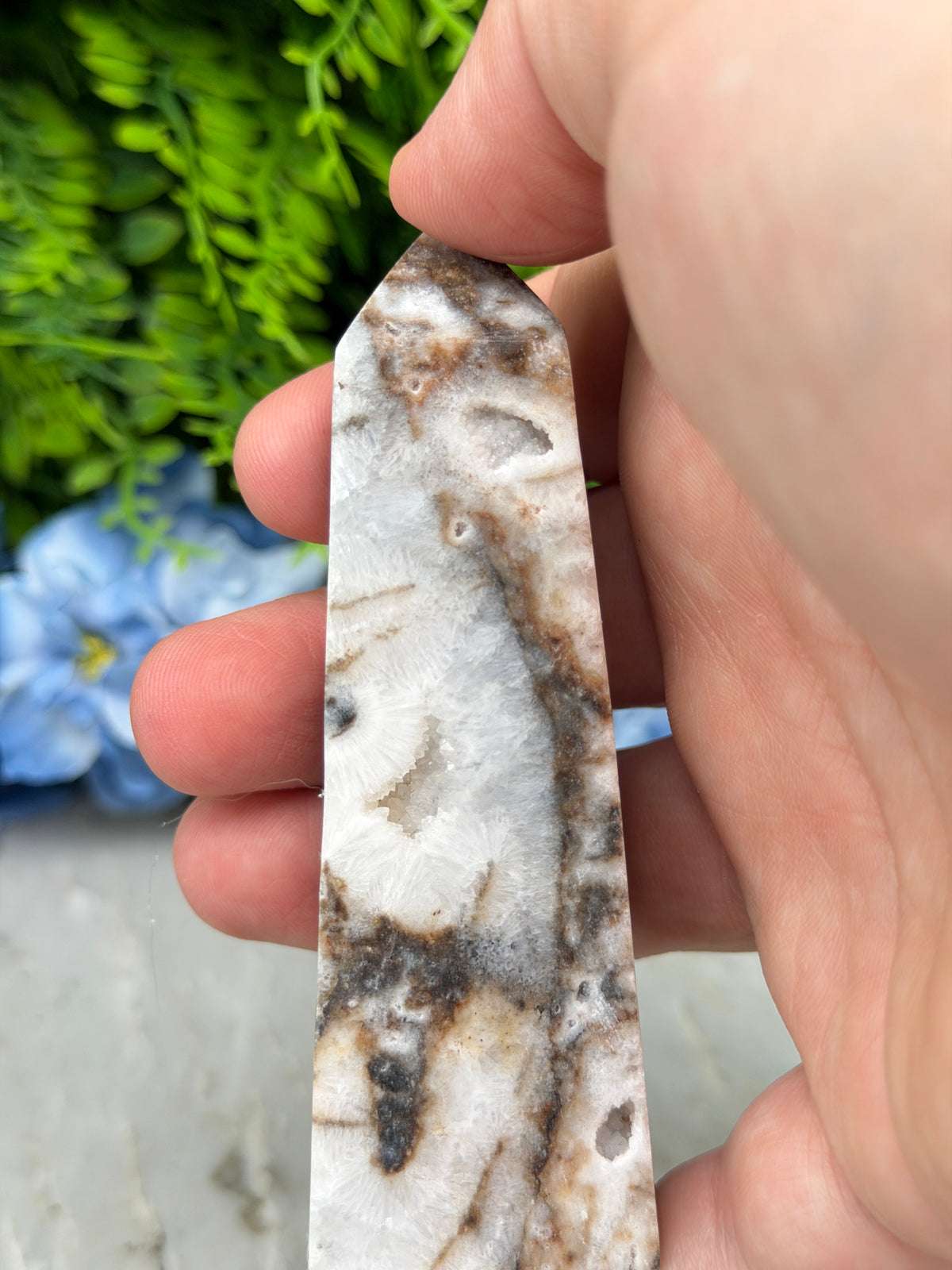 A close-up image of a hand holding a piece of rock with a unique, textured surface.