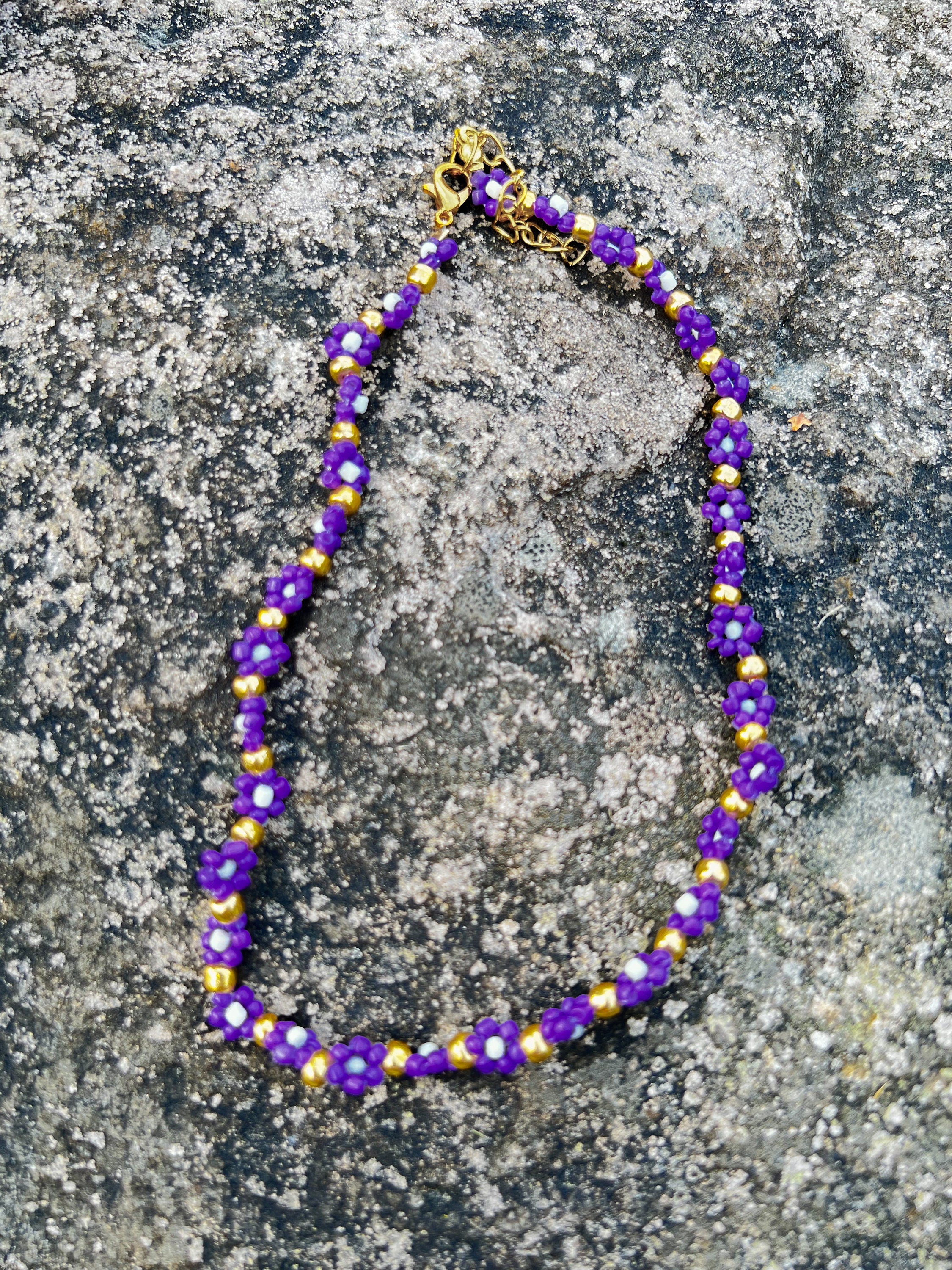 Halskette mit lila, weißen und goldenen Blumen