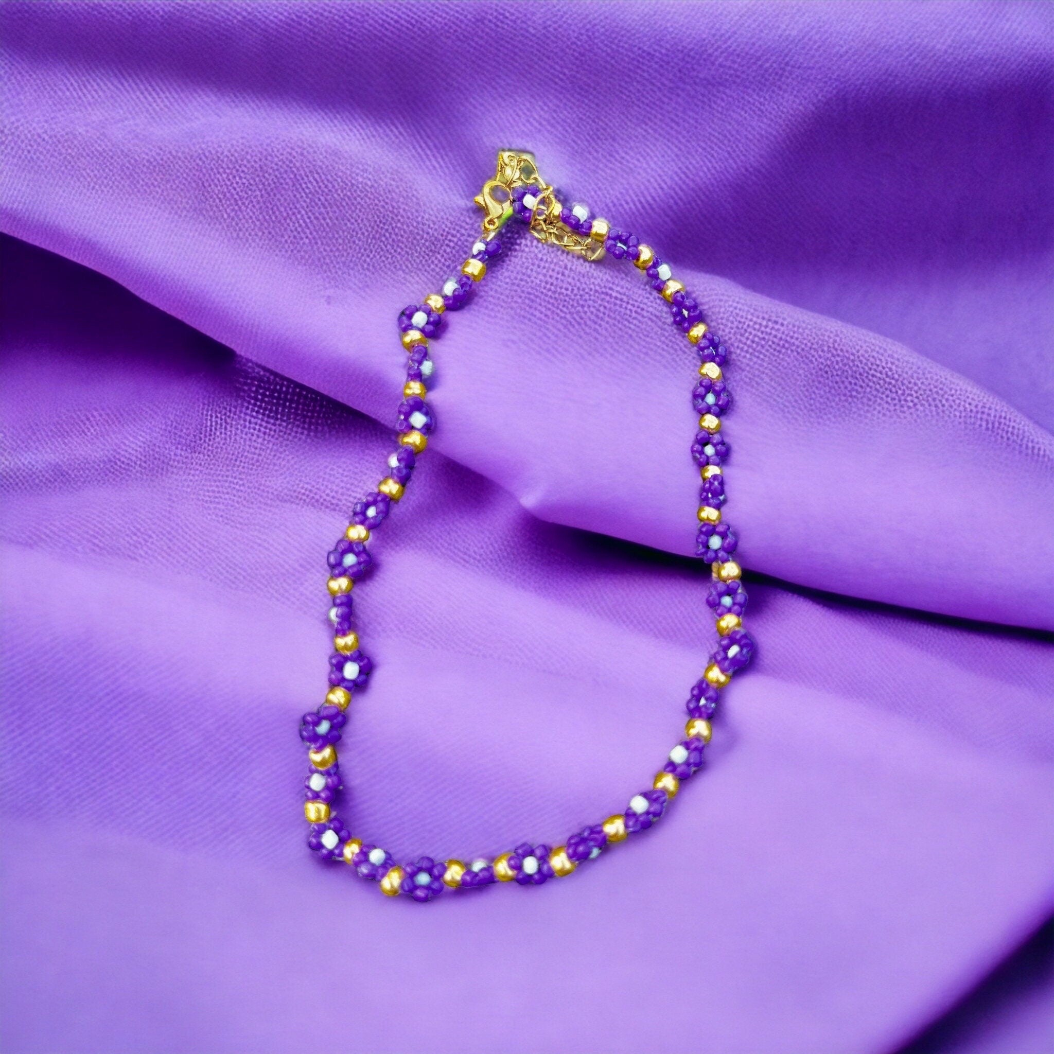 Halskette mit lila, weißen und goldenen Blumen