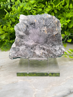 a piece of crystal or rock on display, placed on a clear stand.