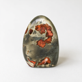 a piece of jade with a unique, colorful pattern of red and orange hues.
