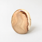 a round, light brown stone with a marbled pattern, sitting on a plain white surface.
