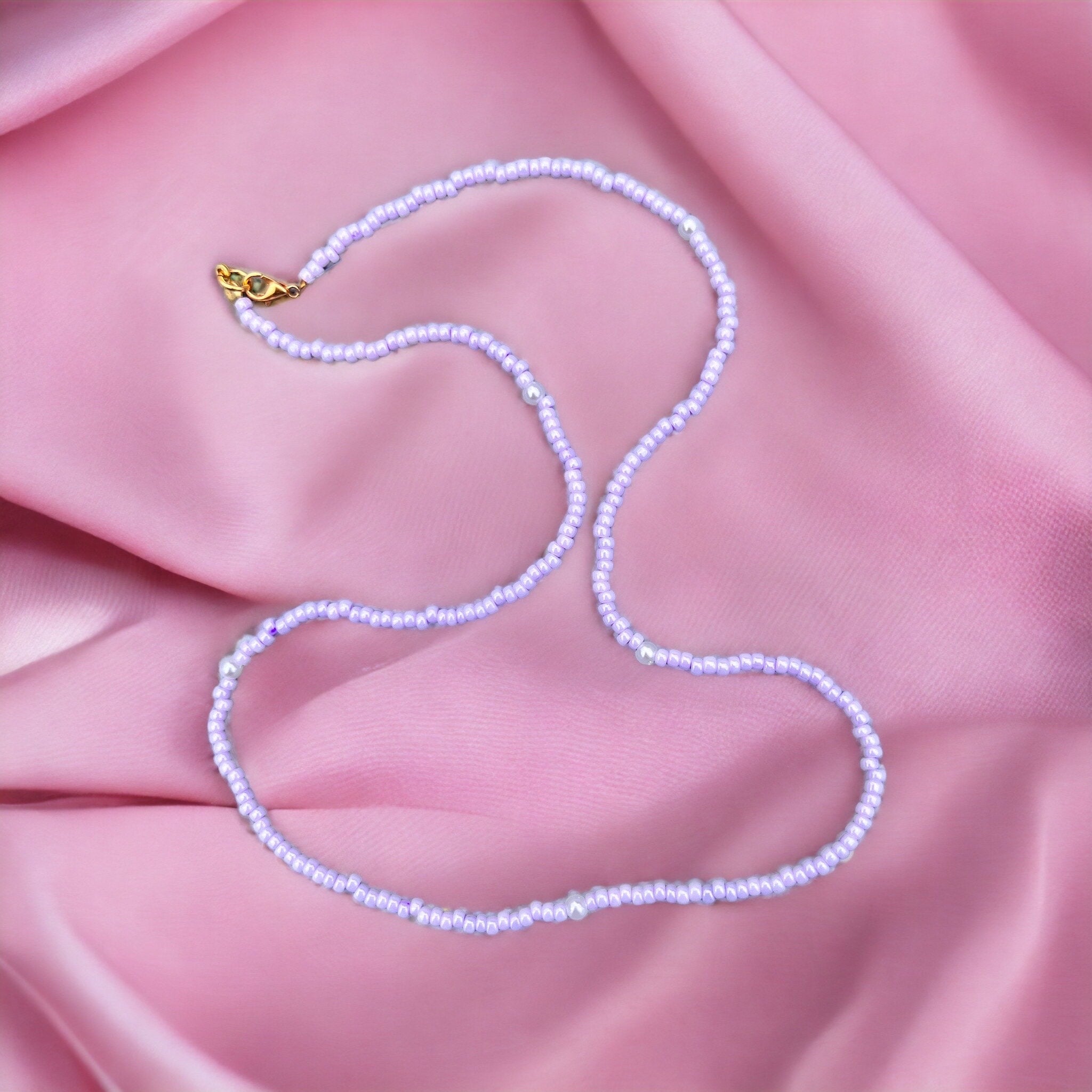 Halskette aus lila Glasperlen und Perlen