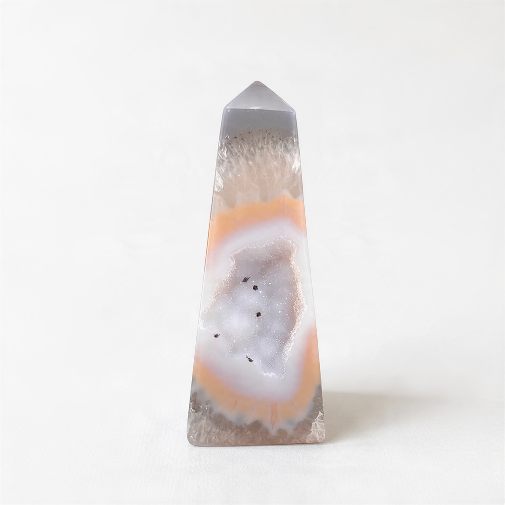 a clear, triangular-shaped stone with a unique, colorful, and intricate pattern inside, resembling a slice of a gemstone.