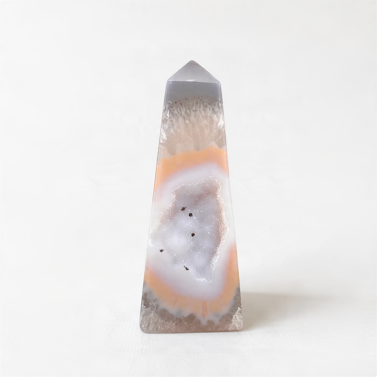 a clear, triangular-shaped stone with a unique, colorful, and intricate pattern inside, resembling a slice of a gemstone.