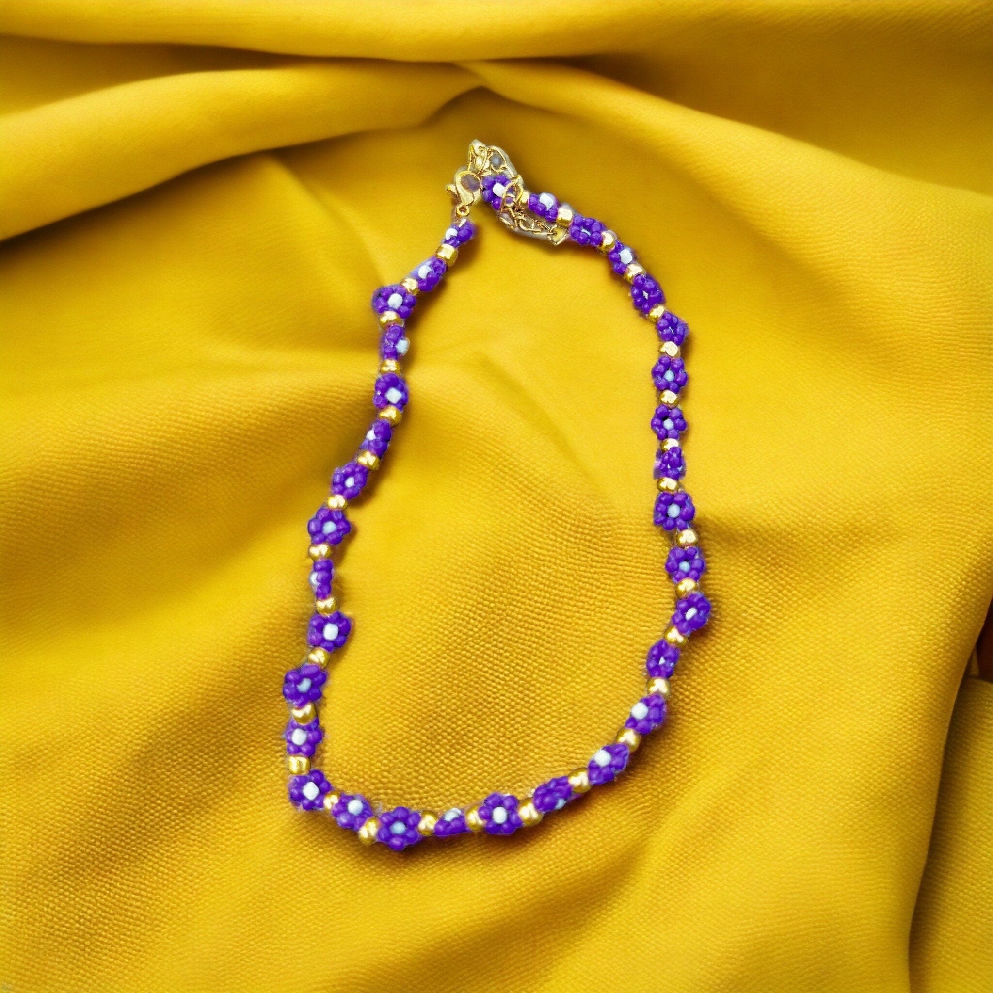 Halskette mit lila, weißen und goldenen Blumen