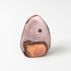 A single, unique rock with a speckled surface and a small hole in the center, set against a plain white background.