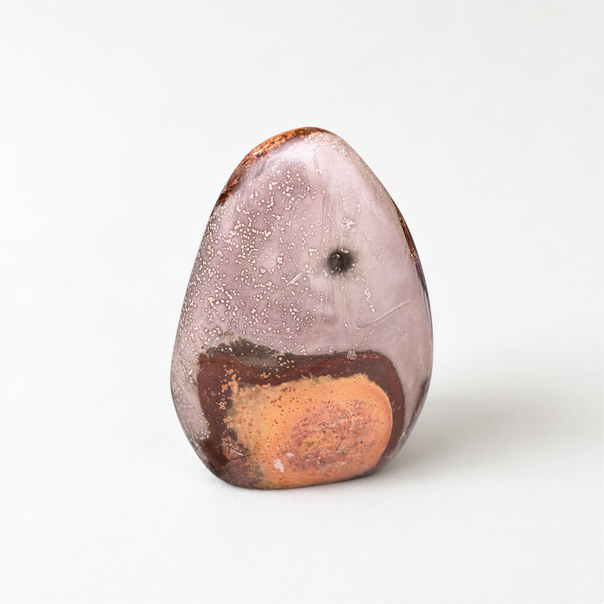 A single, unique rock with a speckled surface and a small hole in the center, set against a plain white background.
