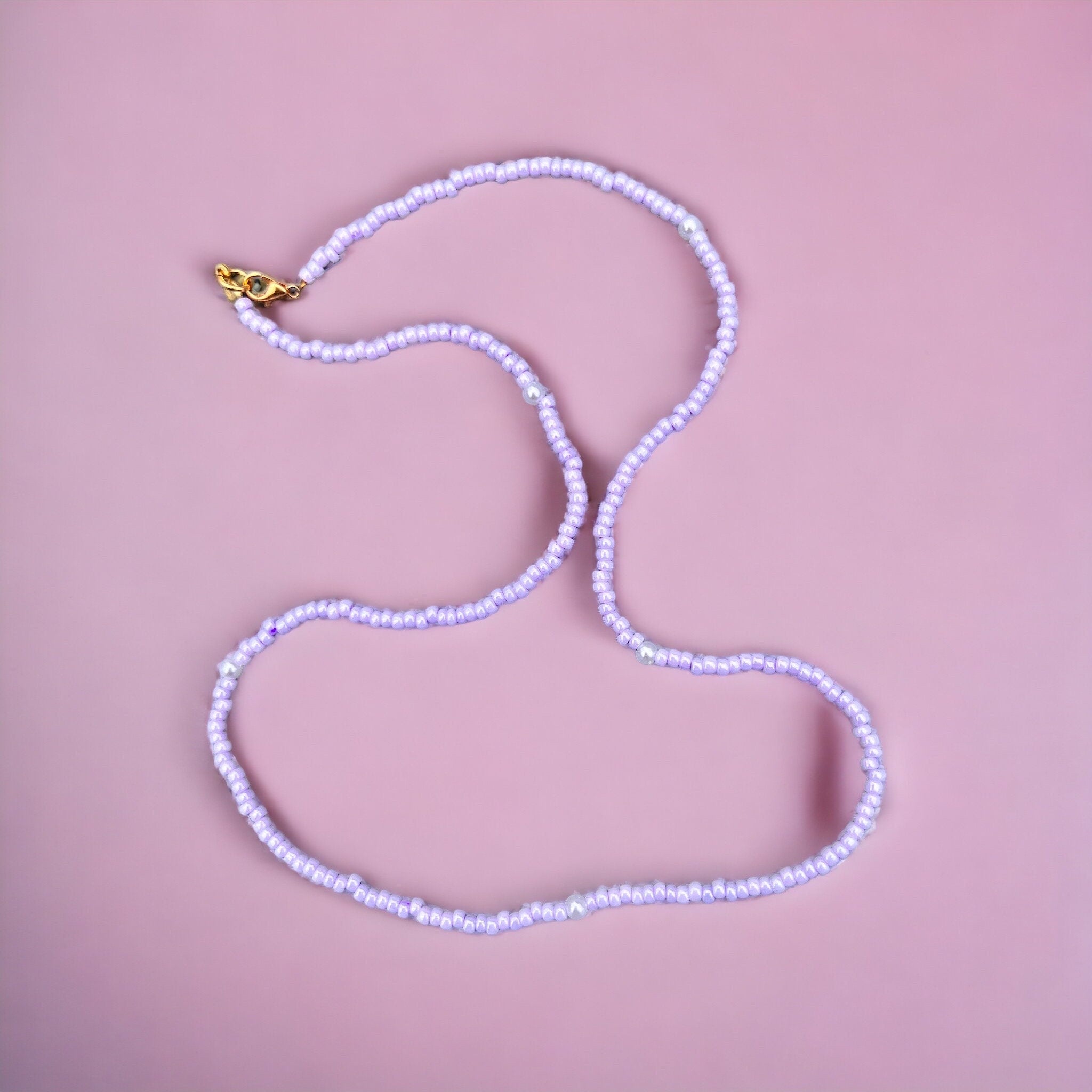 Halskette aus lila Glasperlen und Perlen