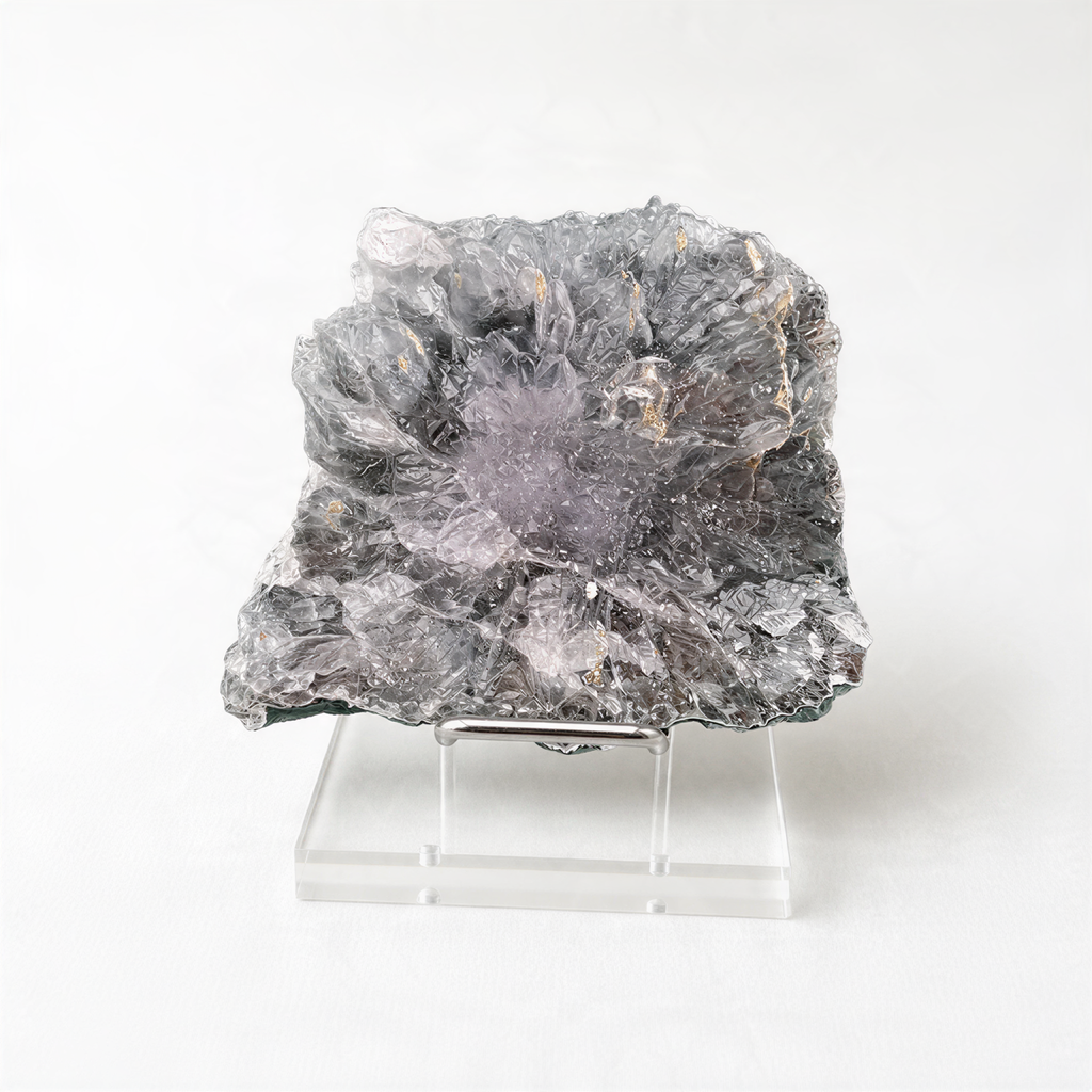 a large, irregularly shaped crystal or rock formation, possibly a mineral or gemstone, placed on a clear stand.
