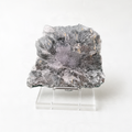 a large, irregularly shaped crystal or rock formation, possibly a mineral or gemstone, placed on a clear stand.