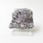 a large, irregularly shaped crystal or rock formation, possibly a mineral or gemstone, placed on a clear stand.