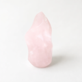 A single, light pink crystal sits alone on a plain white background.