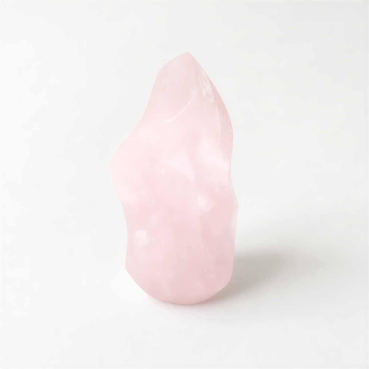 A single, light pink crystal sits alone on a plain white background.