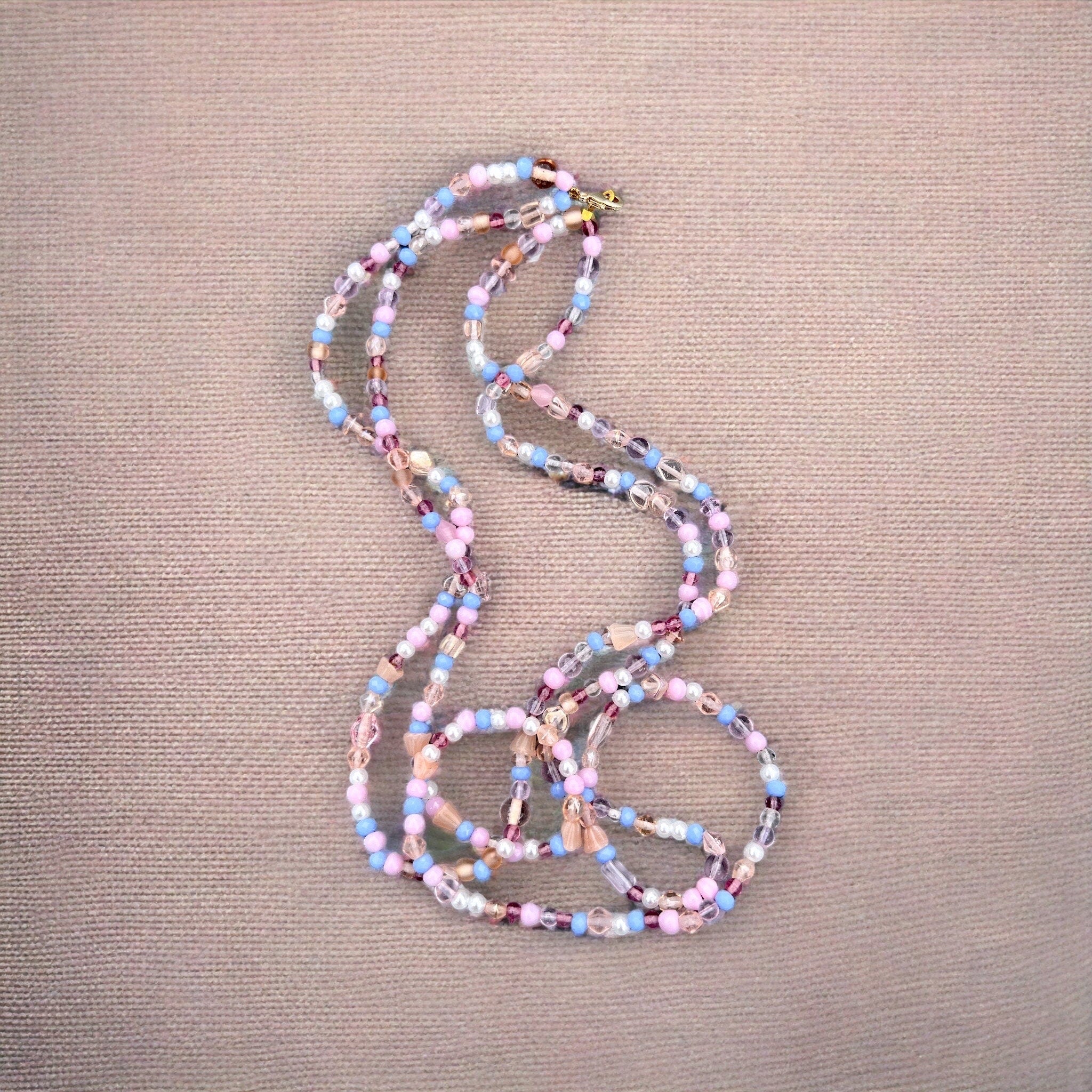 Halskette mit Perlen in Lila, Weiß, Rosa und Gold