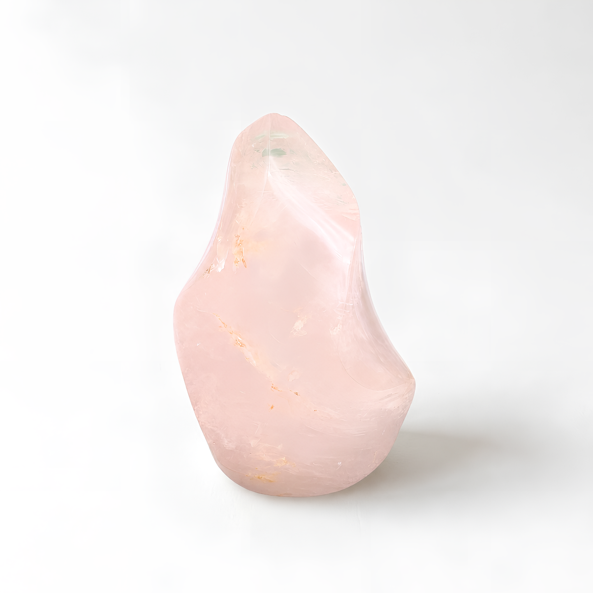 A single, unique pink crystal sits on a white background.