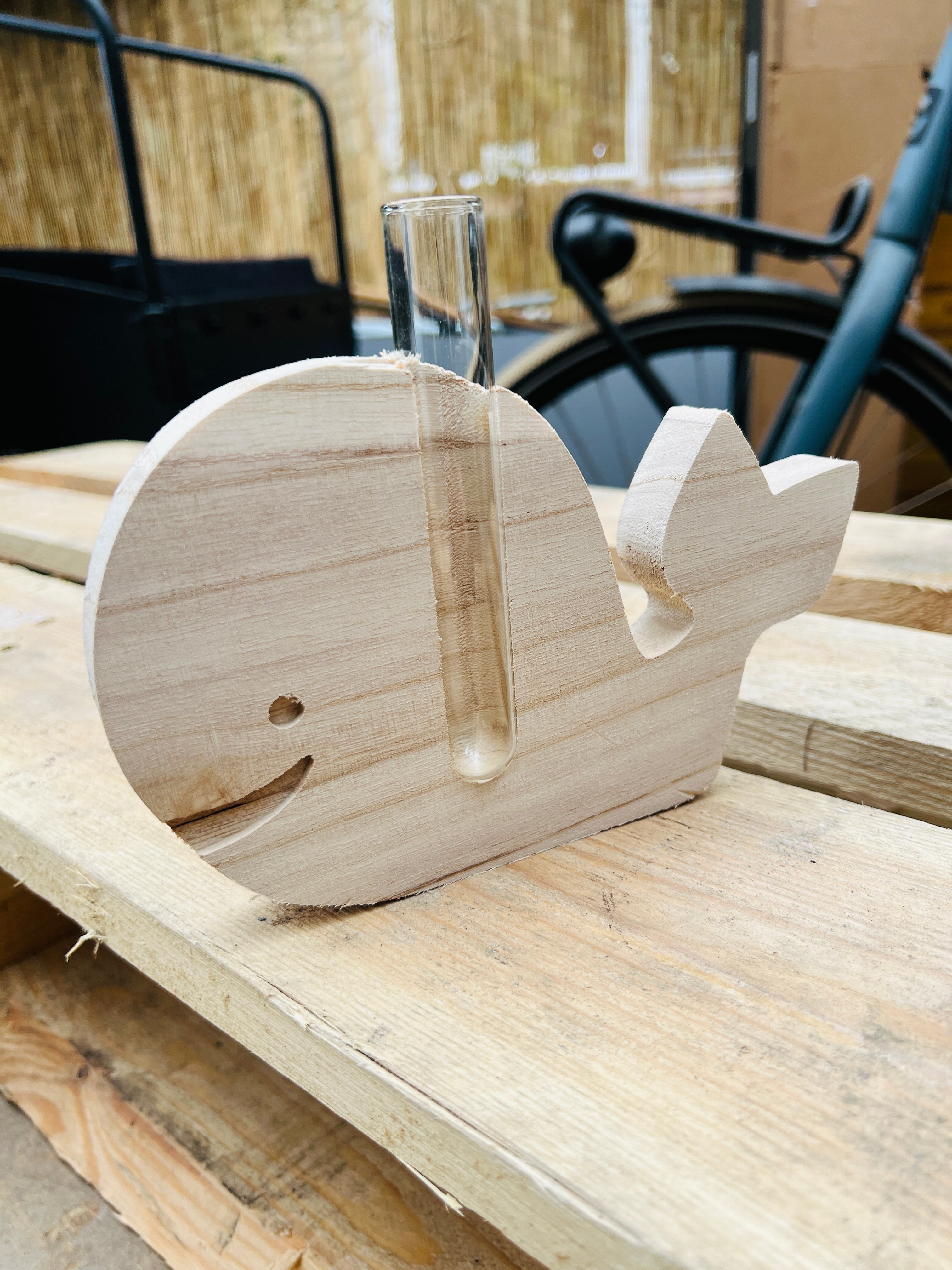 Wooden whale with a small vase