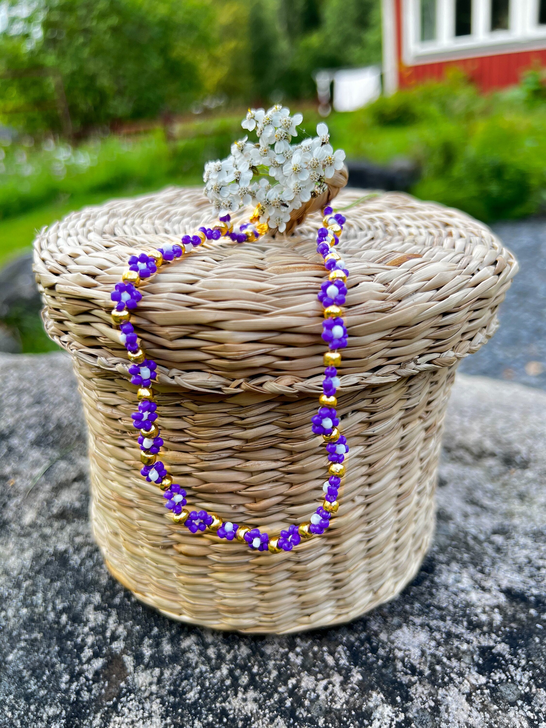 Halskette mit lila, weißen und goldenen Blumen