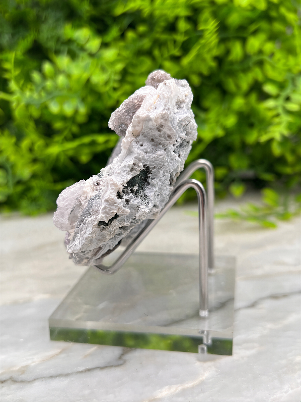 a clear glass display case containing a large, irregularly shaped crystal or rock formation.