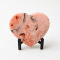 a heart-shaped pink rock with a unique, textured surface.