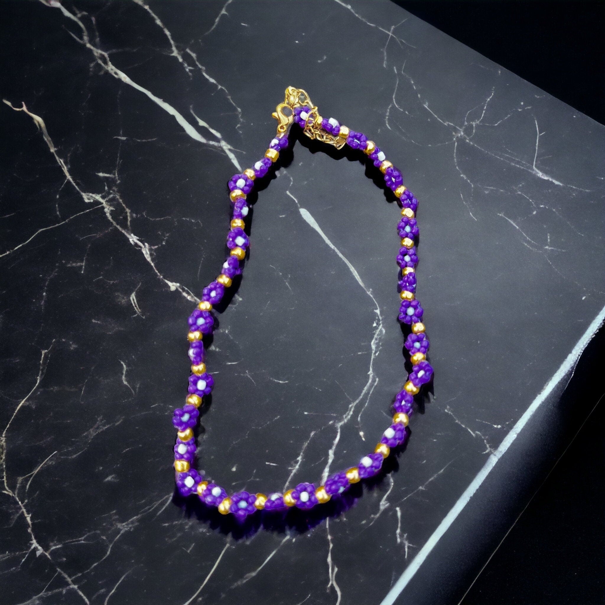 Halskette mit lila, weißen und goldenen Blumen