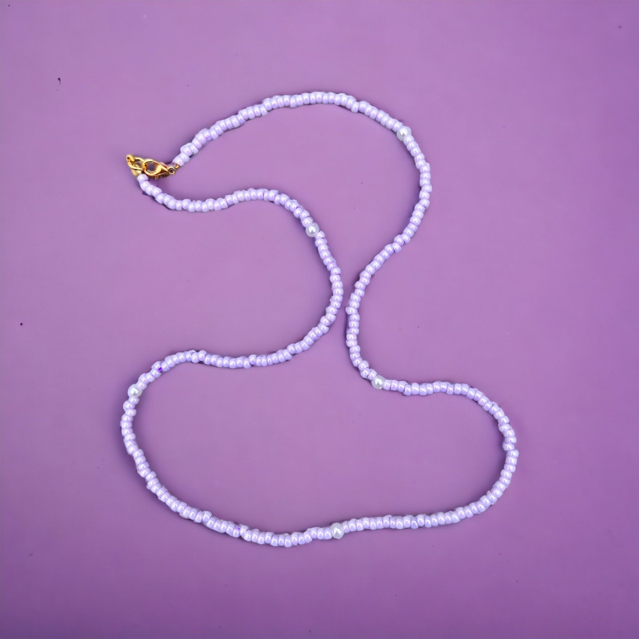 Halskette aus lila Glasperlen und Perlen