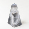 A triangular, geode-like rock formation with a central opening revealing a crystal-like interior.