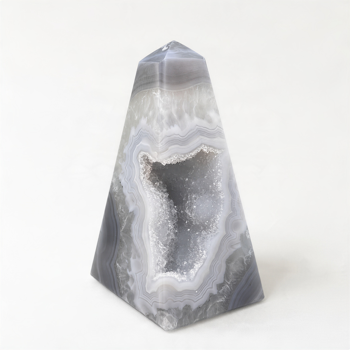 A triangular, geode-like rock formation with a central opening revealing a crystal-like interior.
