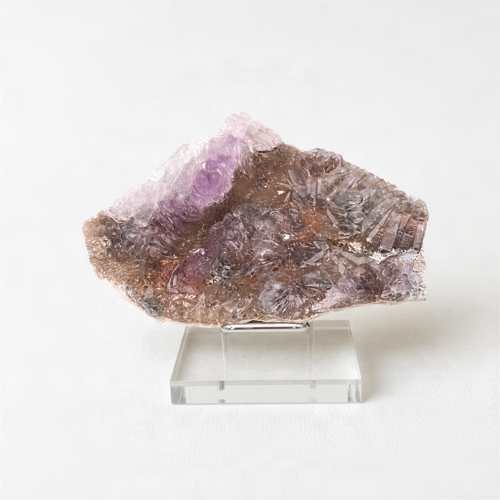 a clear glass display case containing a piece of purple crystal or gemstone.