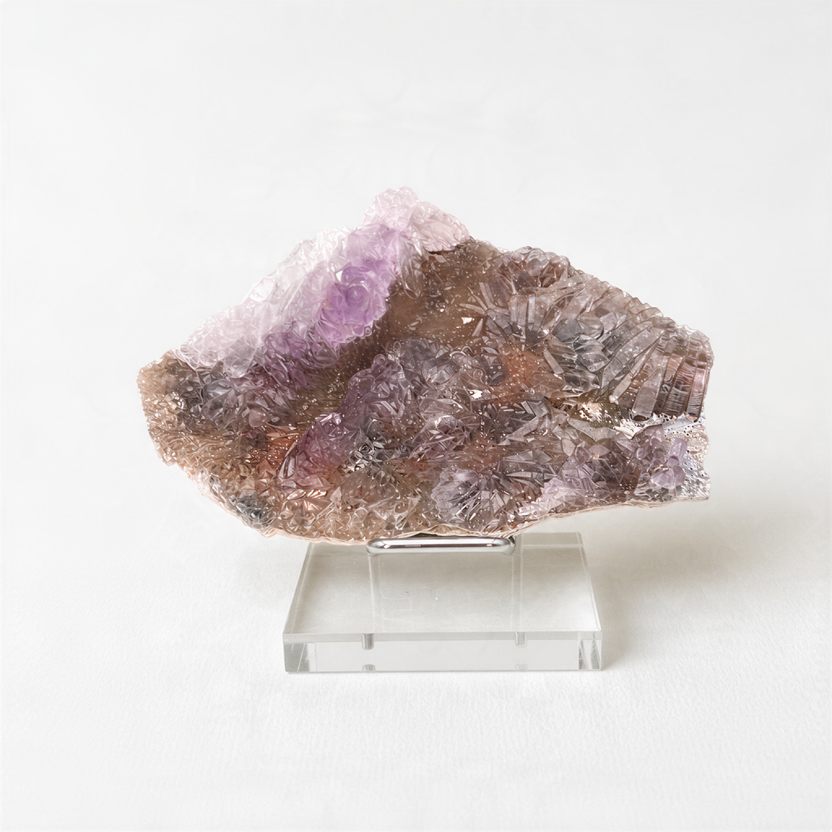 a clear glass display case containing a piece of purple crystal or gemstone.