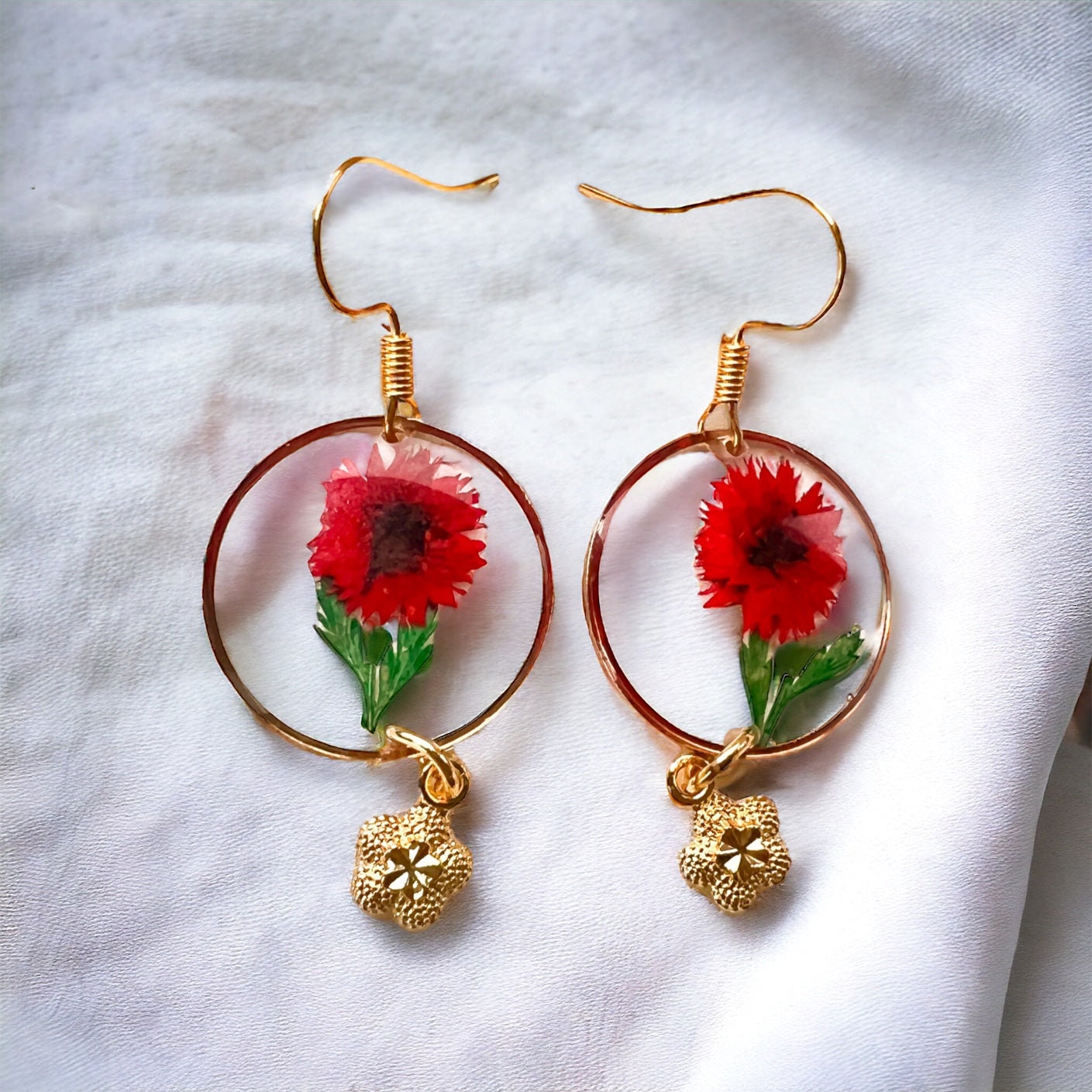 Rote und goldene Ohrringe mit getrockneten Blumen