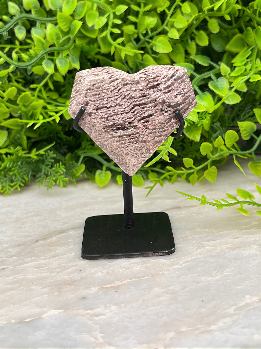 a stone sculpture of a heart on a pedestal