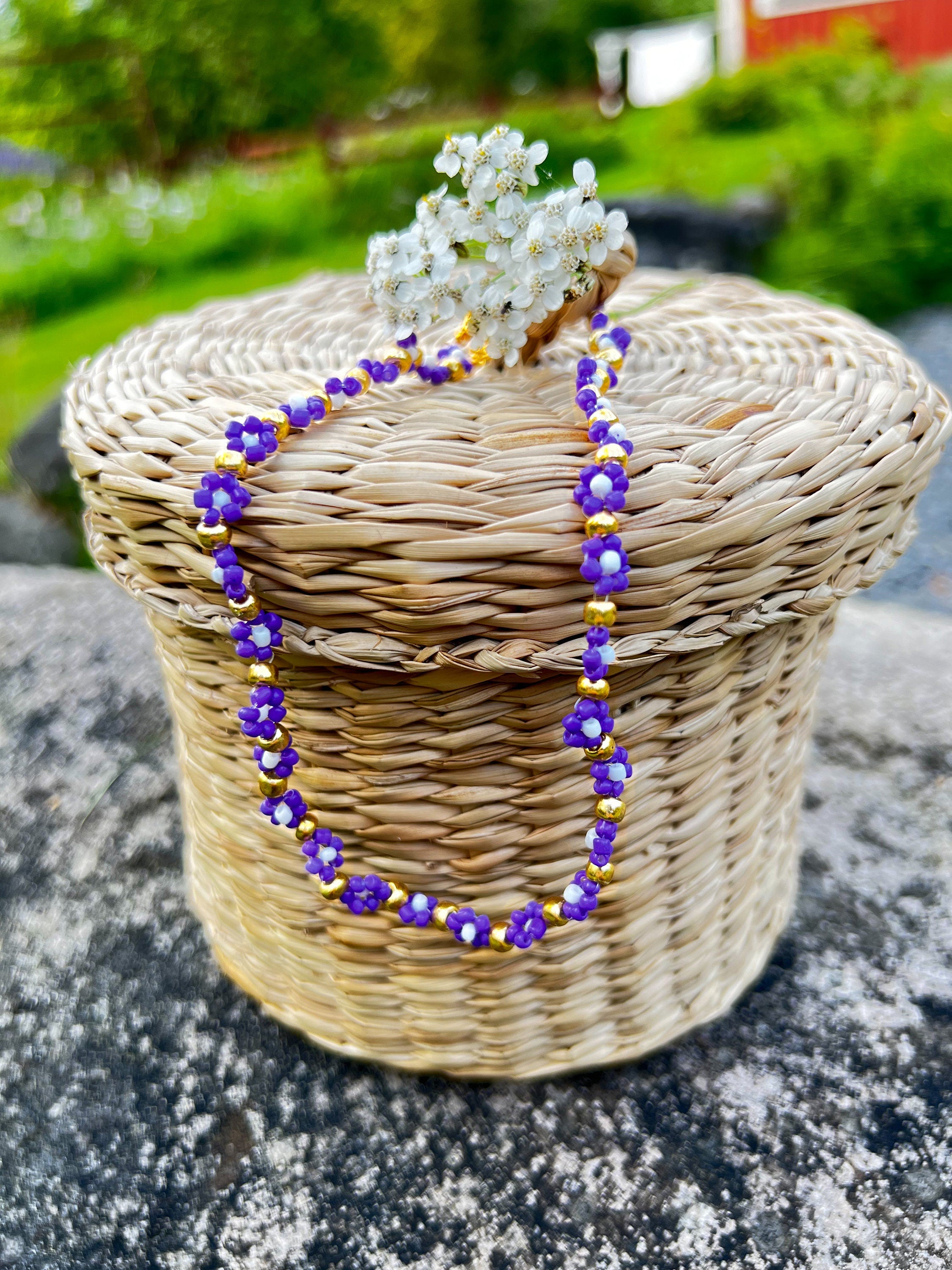 Halskette mit lila, weißen und goldenen Blumen