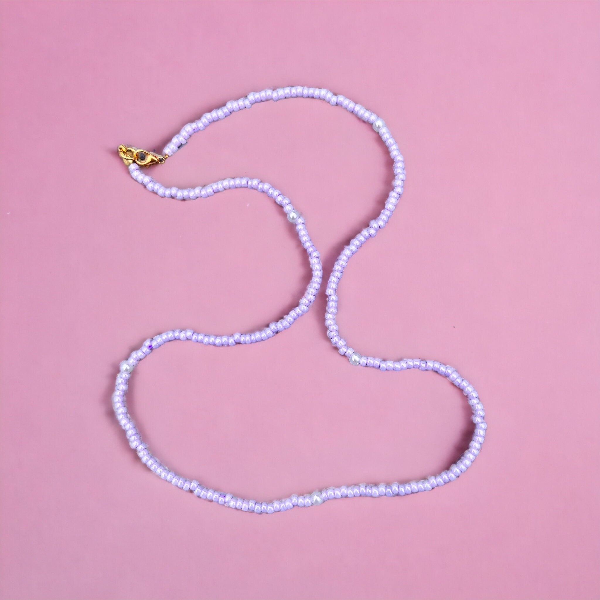 Halskette aus lila Glasperlen und Perlen