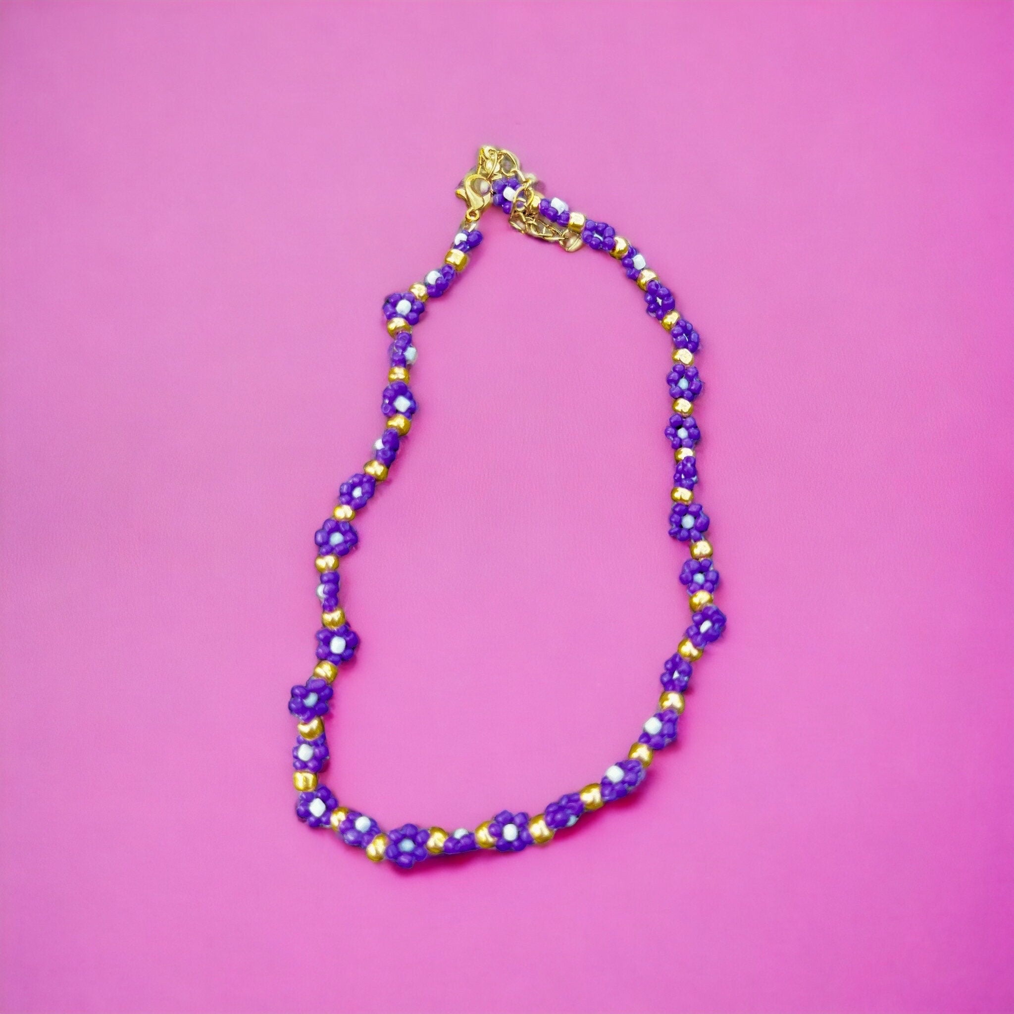 Halskette mit lila, weißen und goldenen Blumen